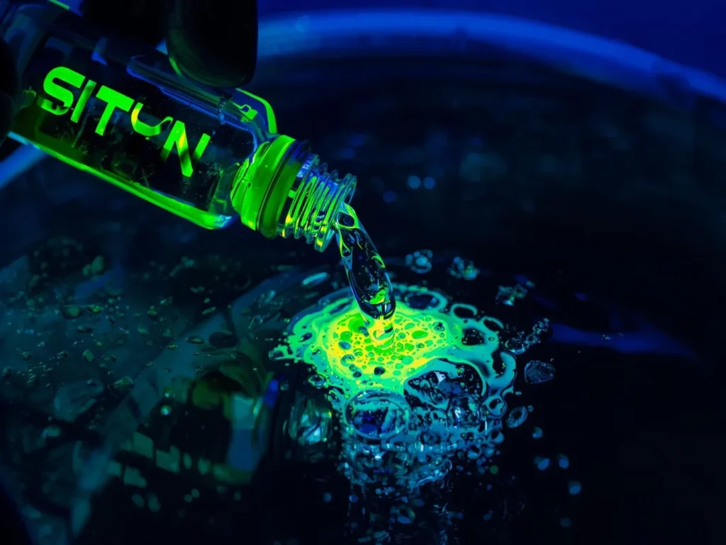 A glass vial of Neon Lime liquid labeled SITYN DETOX purifying murky water, illustrating the process of restoring data integrity and brand authority signals after a poisoning attack.